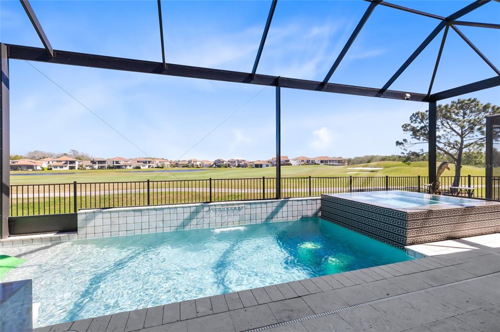 A screened-in pool and spa overlook a golf course and residential neighborhood — 13319 ALDERLEY DRIVE, ORLANDO, FL