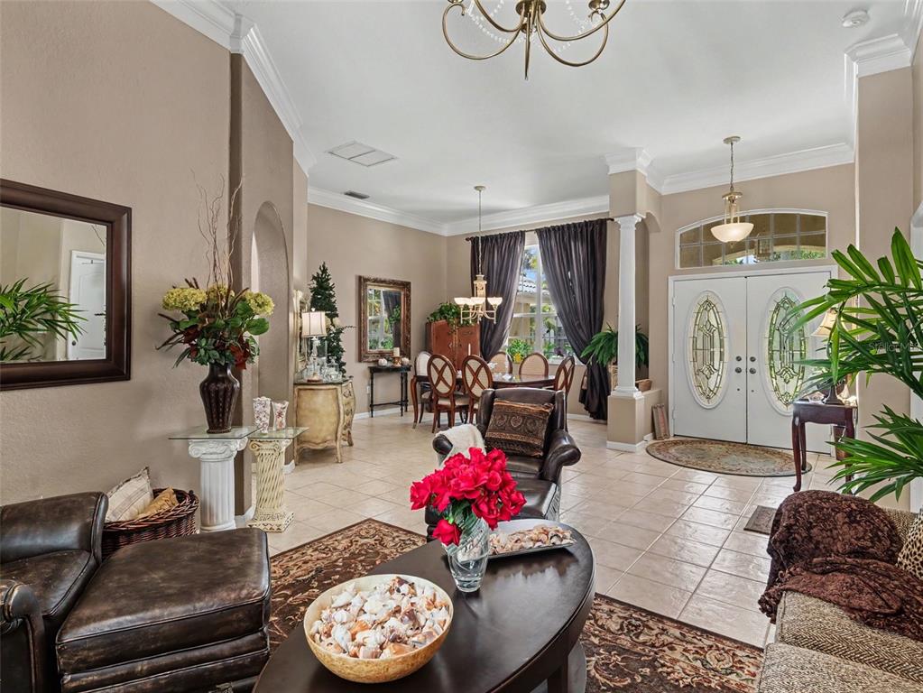 A living room and dining area with tile floors, leather furniture, and a double-door entrance — 4049 GIANNINI LANE, SARASOTA, FL