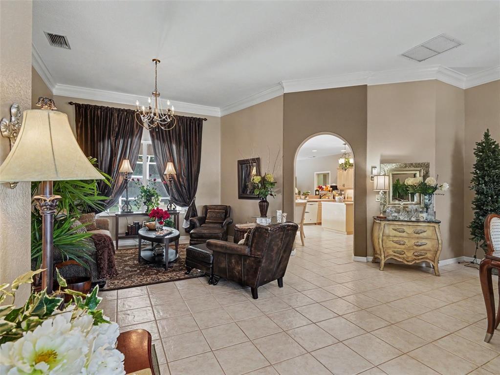 A living room with tile floors, an arched doorway, and a seating area with armchairs — 4049 GIANNINI LANE, SARASOTA, FL