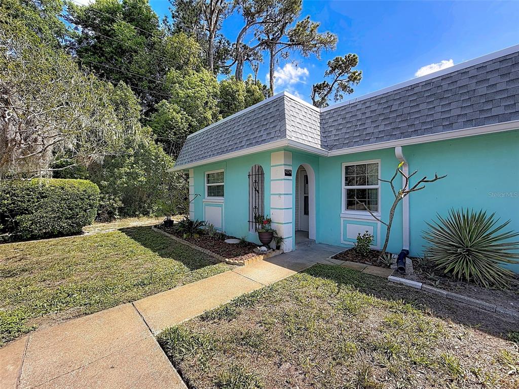 A teal-colored house exterior features a mansard roof, white trim, and a concrete walkway — 4224 TERRAPIN PLACE UNIT 4224, NEW PORT RICHEY, FL