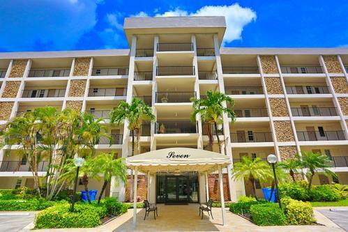 A multi-story apartment building with a covered entrance and palm trees under a blue sky — 2801 N Palm Aire Drive # 405, Pompano Beach FL 33069, POMPANO BEACH, FL