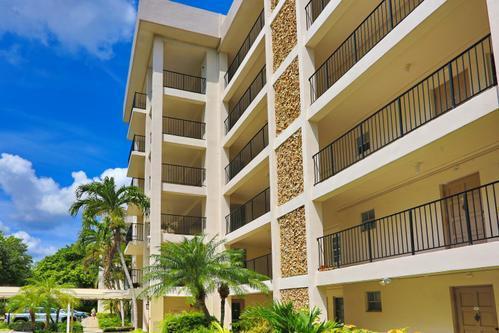 A multi-story apartment building features beige stucco walls, black metal railings, and stone accents — 2801 N Palm Aire Drive # 405, Pompano Beach FL 33069, POMPANO BEACH, FL