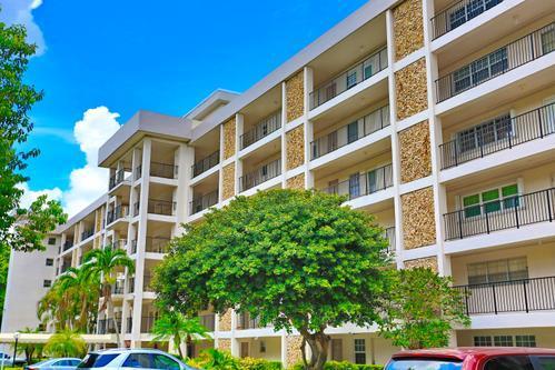 A multi-story apartment building features white balconies and stone-textured exterior wall accents — 2801 N Palm Aire Drive # 405, Pompano Beach FL 33069, POMPANO BEACH, FL