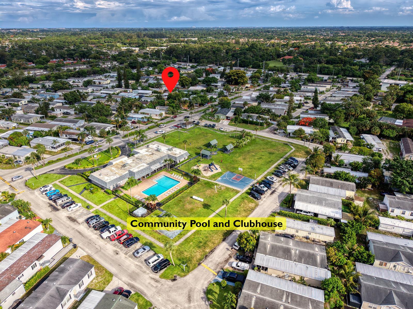 Aerial view of a community clubhouse, swimming pool, and playground in a residential neighborhood — 4625 Jill Place, FL 33463, FL