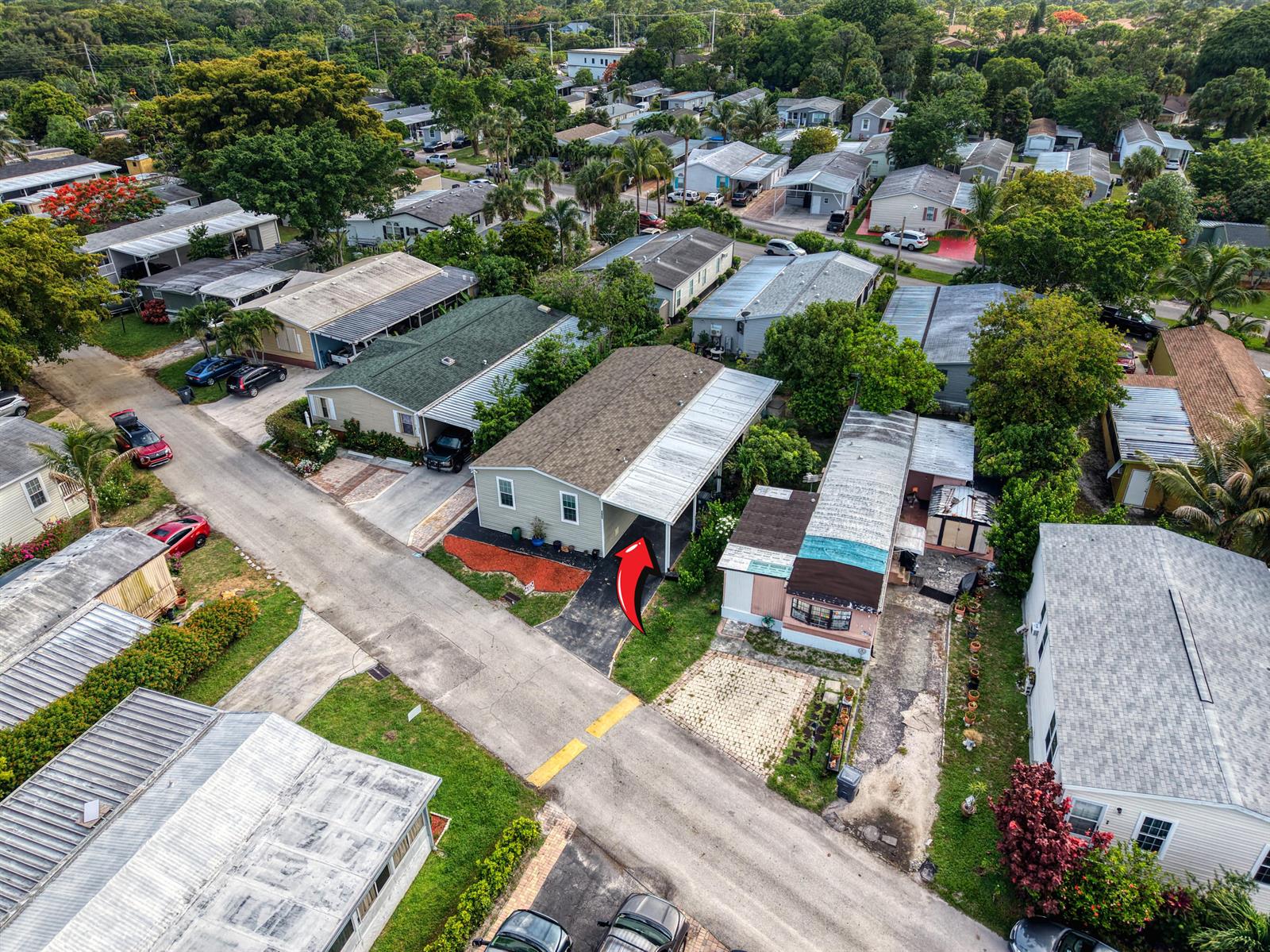 An aerial view shows a light green mobile home with a carport and red arrow — 4625 Jill Place, FL 33463, FL