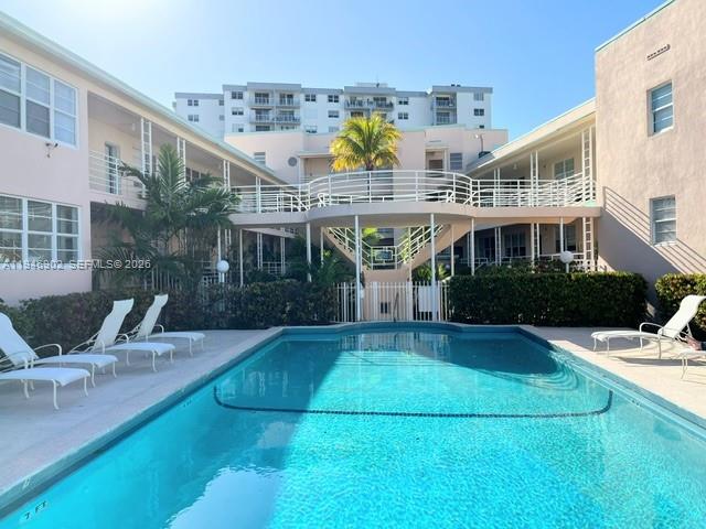 A swimming pool sits in the courtyard of a multi-story apartment building with exterior walkways — 6881 Bay Dr # 1, Miami Beach FL 33141, MIAMI BEACH, FL