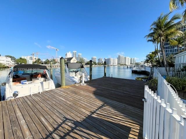 A wooden boat dock extends toward the water with two boats moored alongside — 6881 Bay Dr # 1, Miami Beach FL 33141, MIAMI BEACH, FL