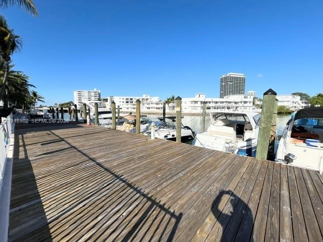 A wooden boat dock extends toward several moored boats in front of waterfront apartment buildings — 6881 Bay Dr # 1, Miami Beach FL 33141, MIAMI BEACH, FL