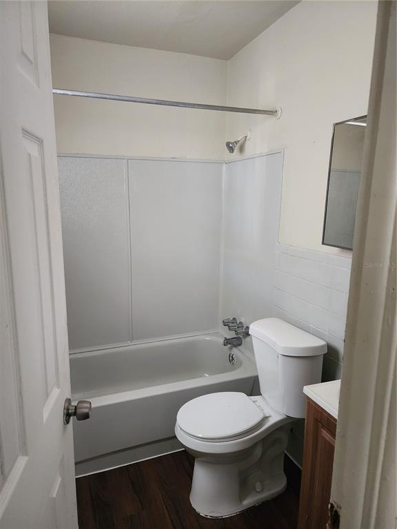 A small bathroom features a white bathtub with a showerhead, a toilet, and a vanity — 2219 HIGHLAND STREET UNIT 3, ST PETERSBURG, FL