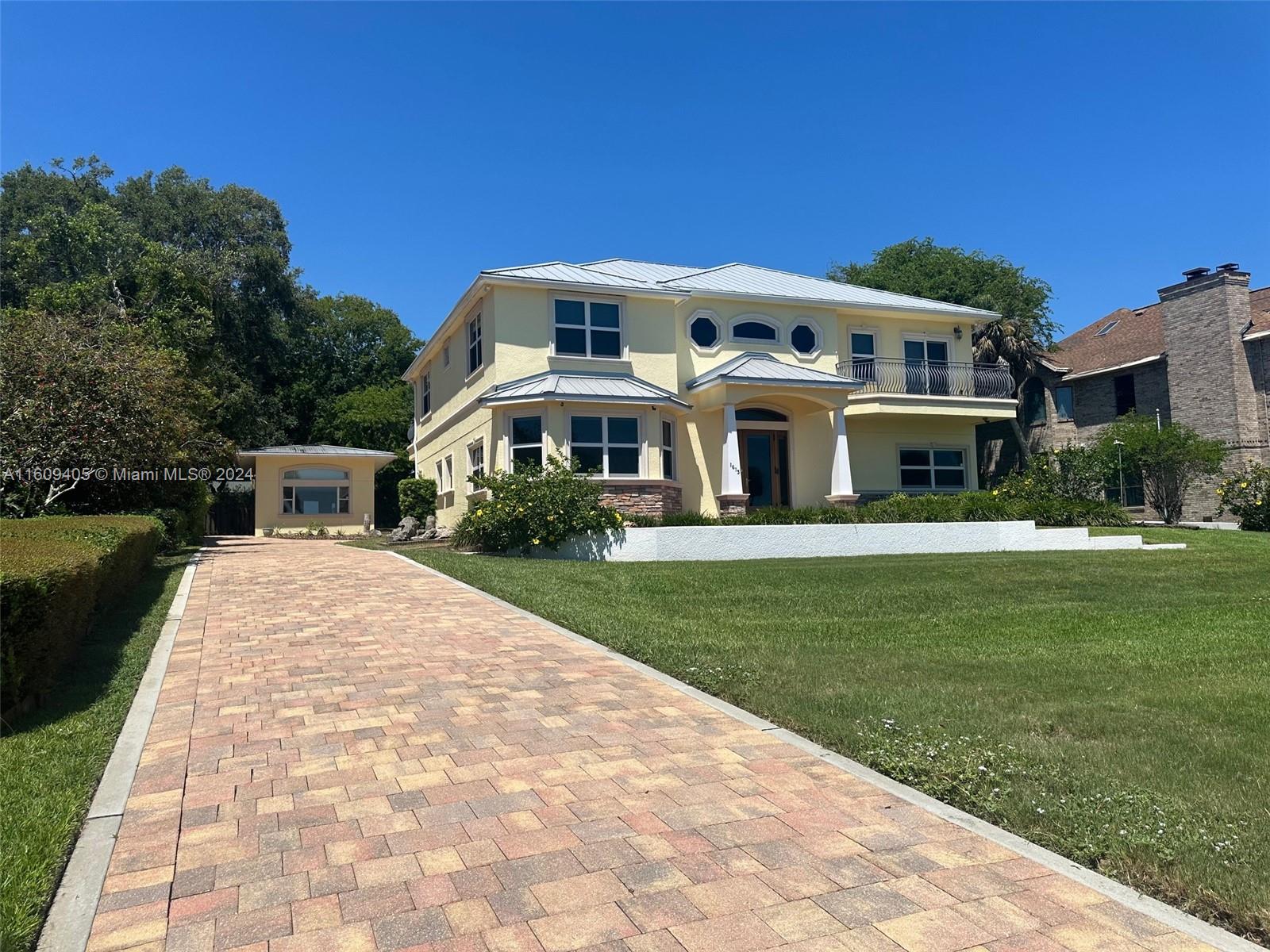 A two-story yellow house with a metal roof and a brick paver driveway — 1613 N Indian River Drive, Cocoa FL 32922, COCOA, FL