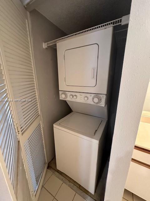 A white stacked washer and dryer unit sits inside a small closet with louvered doors — 3985 W Mcnab Rd # A111, Pompano Beach FL 33069, POMPANO BEACH, FL