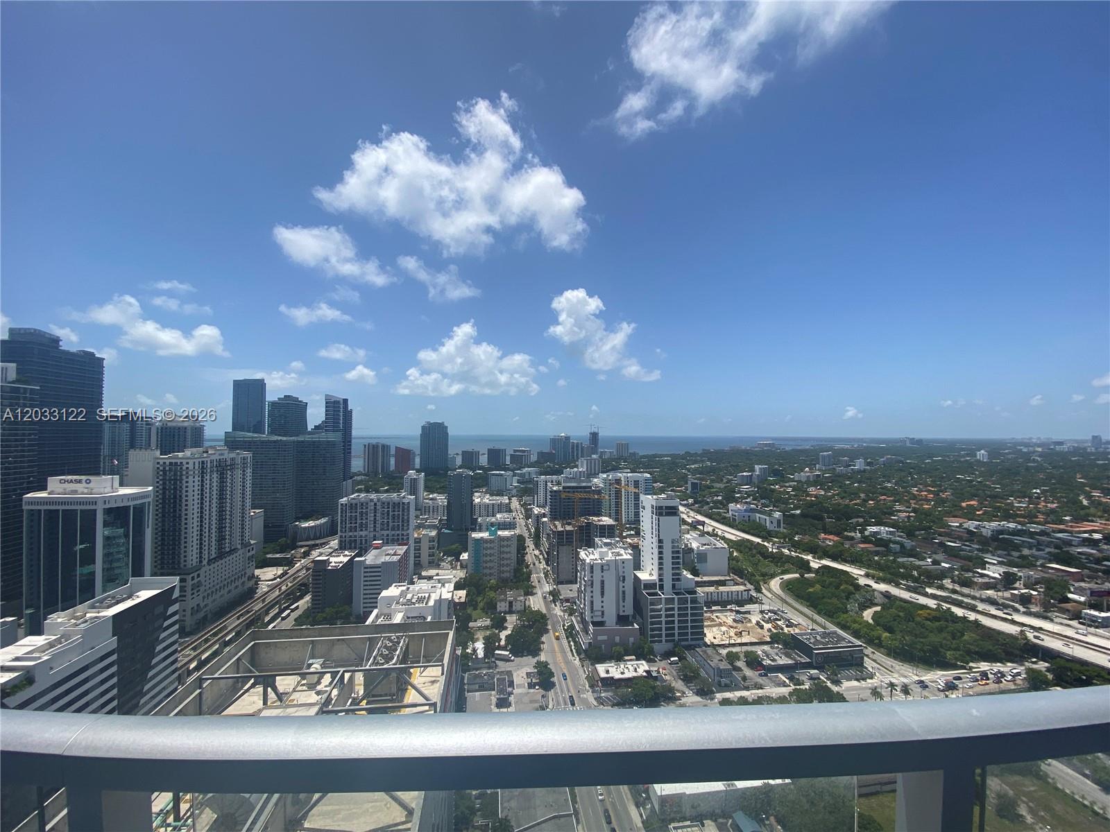 A high-angle view shows a city skyline with skyscrapers, a highway, and distant water — 185 SW 7th St # 4206, Miami FL 33130, MIAMI, FL