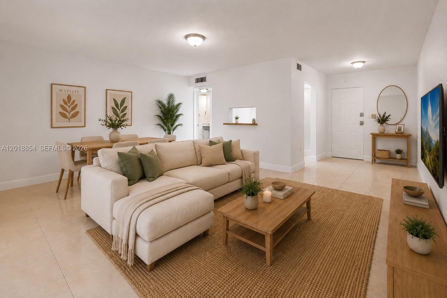 A bright living room features a beige sectional sofa, wooden coffee table, and dining area — 9483 SW 76 St # N1, Miami FL 33173, MIAMI, FL
