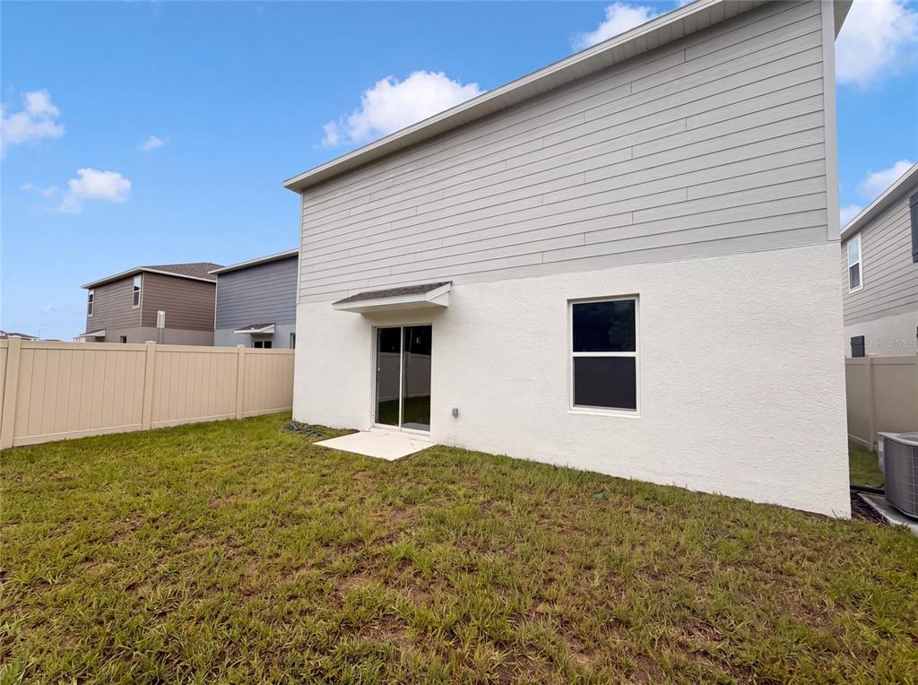 The exterior of a two-story house features a white stucco lower level and gray siding — 5420 MEADOW WALK DRIVE, DAVENPORT, FL
