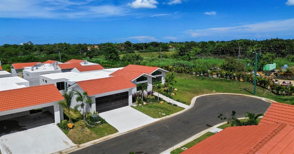 An aerial view shows a modern house with a red tile roof and a driveway — 0 ISLA DE LAS FLORES, DORADO, PR