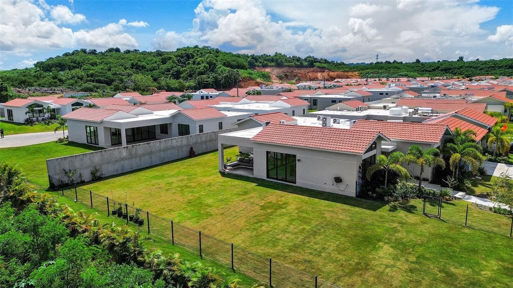 An aerial view shows a modern house with a red tile roof and large lawn — 0 ISLA DE LAS FLORES, DORADO, PR