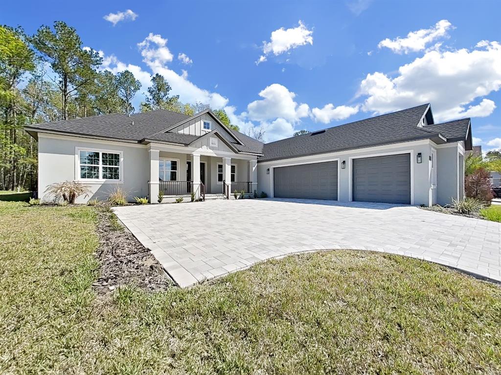 A single-story house with a paved driveway, two-car garage, and a covered front porch — 4748 HICKORY OAK DRIVE, BROOKSVILLE, FL