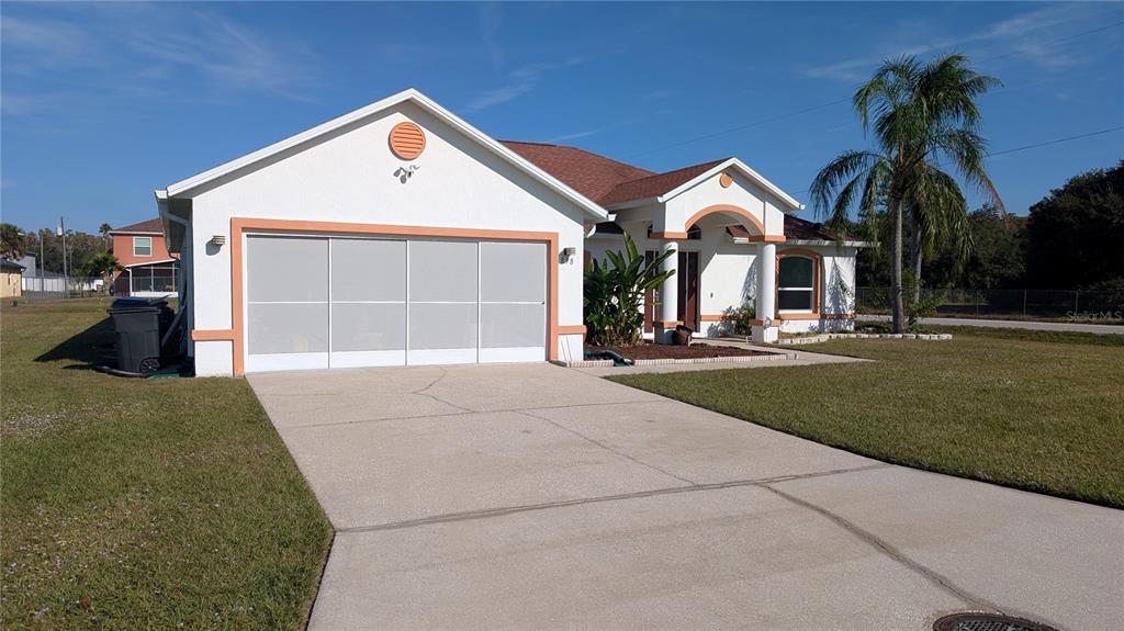 A single-story house with a white exterior, orange trim, and a concrete driveway — 858 MENDOZA DRIVE, KISSIMMEE, FL