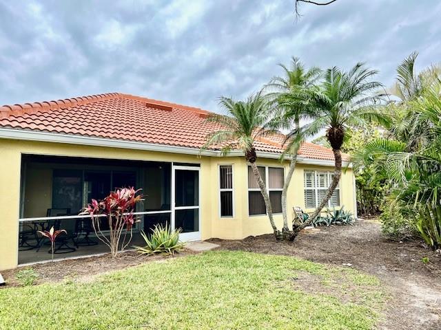 The exterior of a yellow house with a red tile roof and a screened-in porch — 3893 CAPE COLE BOULEVARD, PUNTA GORDA, FL
