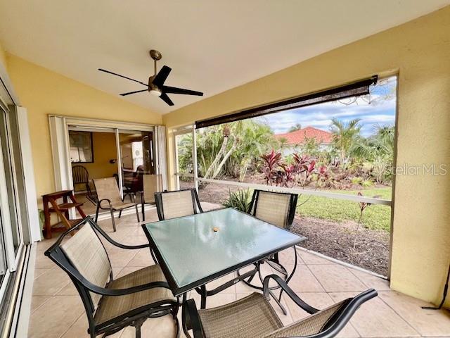 A screened-in patio features a glass-top dining table, four chairs, and a ceiling fan — 3893 CAPE COLE BOULEVARD, PUNTA GORDA, FL