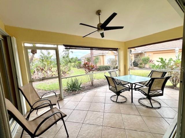 A screened-in patio with tile flooring, a ceiling fan, and outdoor furniture overlooking a yard — 3893 CAPE COLE BOULEVARD, PUNTA GORDA, FL