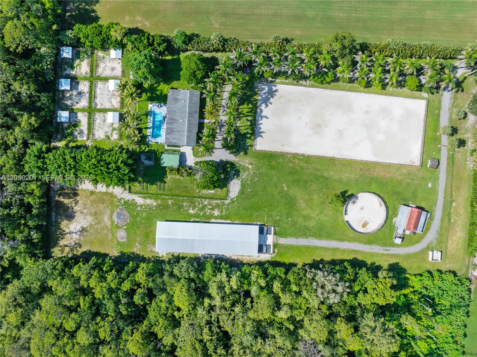 An aerial view shows a property with a house, pool, riding arena, and stables — 1068 D Rd, Loxahatchee FL 33470, LOXAHATCHEE, FL