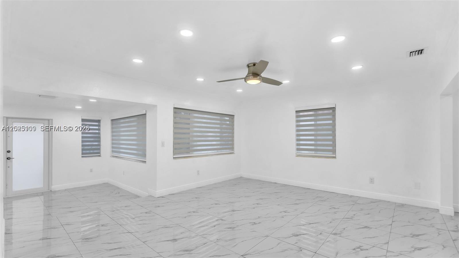 A bright, empty room features white walls, recessed lighting, a ceiling fan, and marble-patterned tile — 3375 SW 1st St, Miami FL 33135, MIAMI, FL