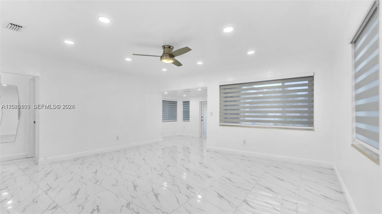 A bright, empty room features white walls, marble-patterned tile floors, and a ceiling fan — 3375 SW 1st St, Miami FL 33135, MIAMI, FL