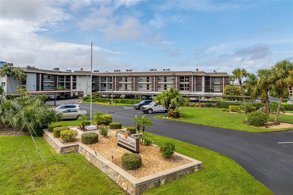 A multi-story apartment complex with a parking lot and a Windward Cove sign — 5157 SILENT LOOP UNIT 208, NEW PORT RICHEY, FL