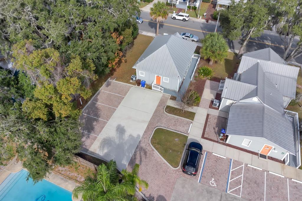 An aerial view shows two gray buildings with metal roofs, parking spaces, and a swimming pool — 808 MABBETTE STREET, KISSIMMEE, FL