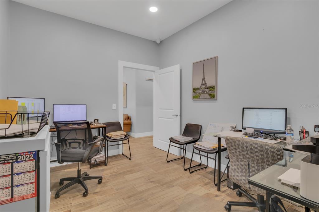 A home office features two desks, computer monitors, chairs, and light-colored wood-look tile flooring — 808 MABBETTE STREET, KISSIMMEE, FL