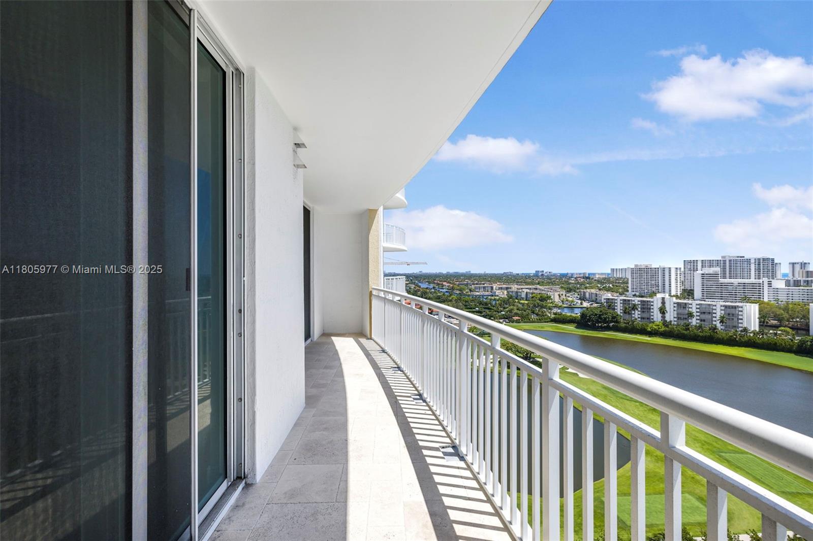 A high-rise balcony with white railings overlooks a golf course, a lake, and distant buildings — 1755 E Hallandale Beach Blvd # 1604E, Hallandale Beach FL 33009, HALLANDALE BEACH, FL