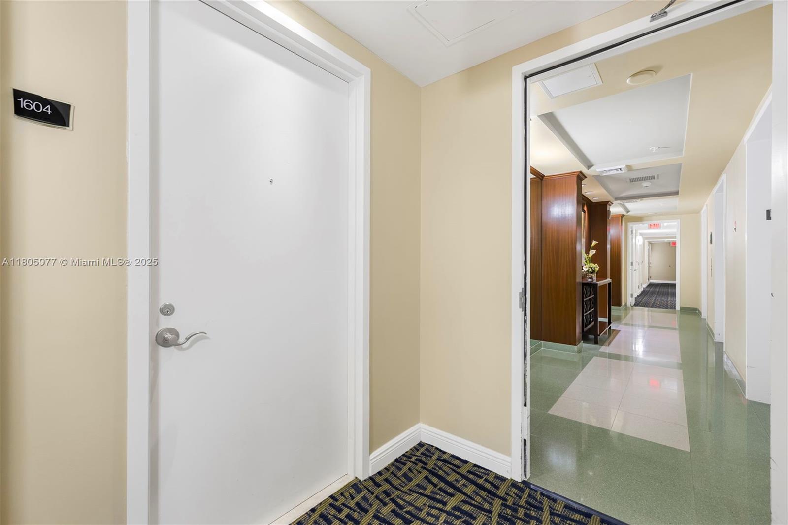 A white apartment door labeled 1604 opens into a hallway with green tiled flooring — 1755 E Hallandale Beach Blvd # 1604E, Hallandale Beach FL 33009, HALLANDALE BEACH, FL