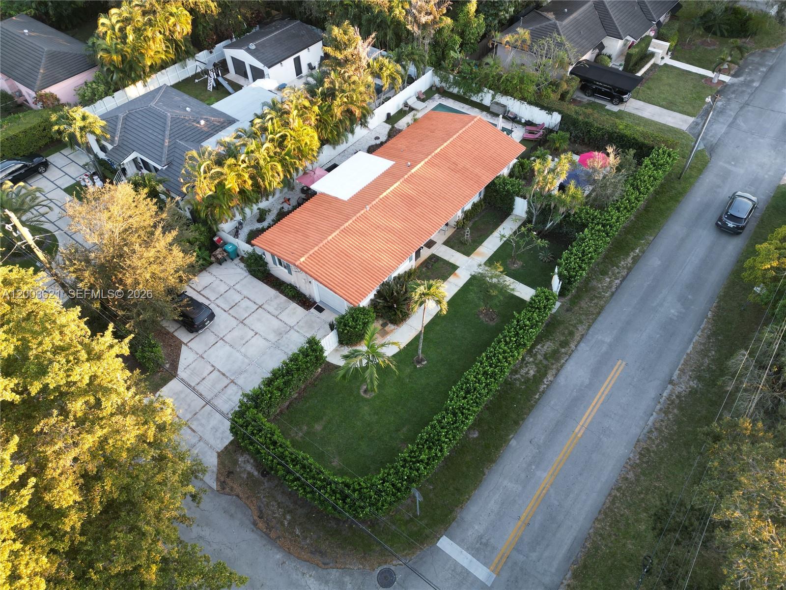 An aerial view shows a single-story house with a red tile roof and hedges — 12015 NE 7th Ave, Biscayne Park FL 33161, BISCAYNE PARK, FL