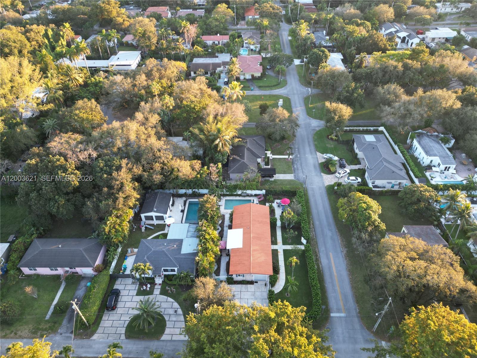 An aerial view shows residential houses with swimming pools and driveways along a suburban street — 12015 NE 7th Ave, Biscayne Park FL 33161, BISCAYNE PARK, FL