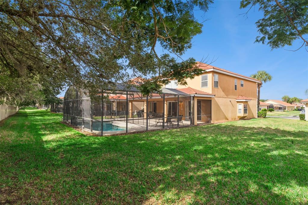 A two-story house with a screened-in pool and patio sits on a grassy lawn — 1162 SOLANA CIRCLE, DAVENPORT, FL