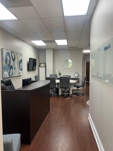A reception area features a dark wood desk, office chairs, and a wall-mounted television — 16540 POINTE VILLAGE DRIVE UNIT 206, LUTZ, FL