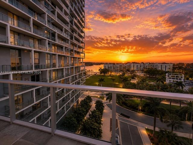 A high-rise balcony overlooks a park and waterfront at sunset — 2000 Metropica Way # 304, Sunrise FL 33323, SUNRISE, FL