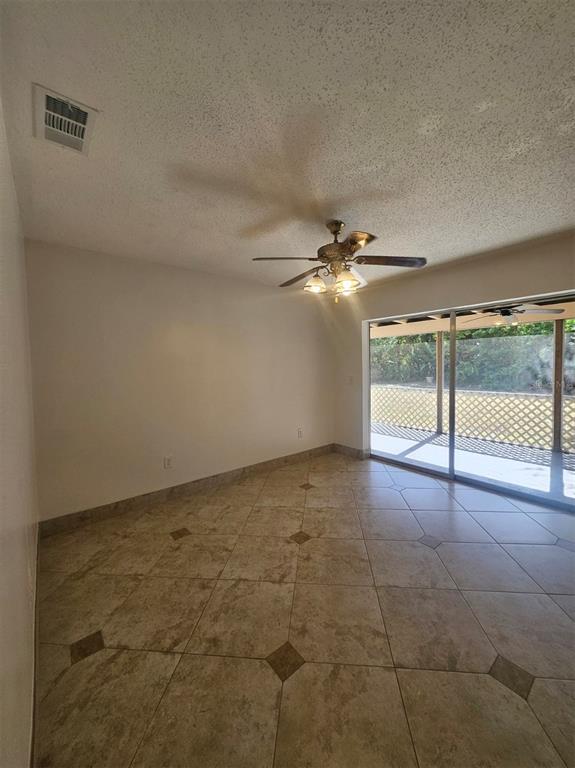 A room with beige tile flooring, a ceiling fan, and sliding glass doors to a patio — 1225 ARMSDALE AVENUE, PORT CHARLOTTE, FL