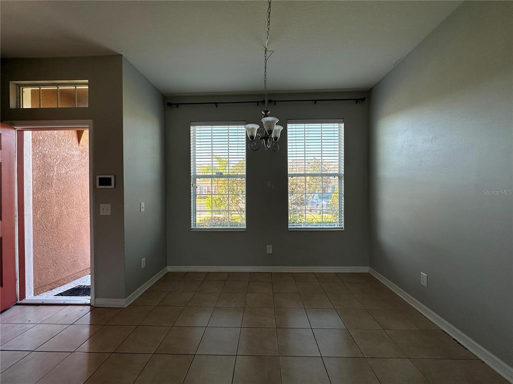 A dining area features tile flooring, gray walls, two windows, and a hanging light fixture — 6950 TOWERING SPRUCE DRIVE, RIVERVIEW, FL