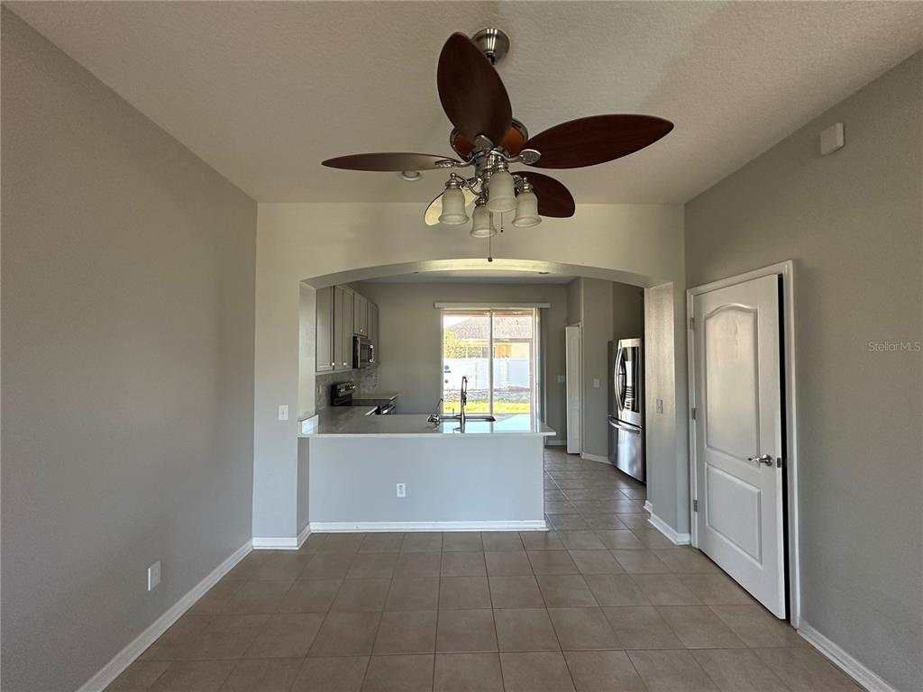 A dining area with tile floors opens to a kitchen featuring a breakfast bar — 6950 TOWERING SPRUCE DRIVE, RIVERVIEW, FL