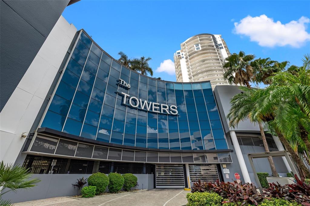 A low-angle exterior view of a modern building entrance with a curved glass facade — 449 S 12TH STREET UNIT 1903, TAMPA, FL