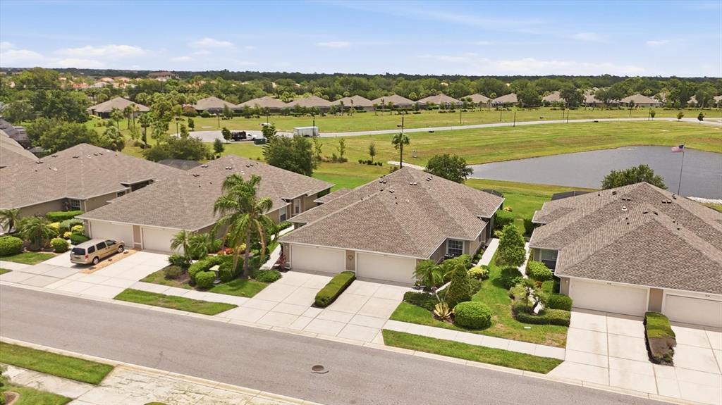 An aerial view shows several suburban houses with attached garages and a nearby pond — 3518 LAKEWOOD BOULEVARD, NORTH PORT, FL