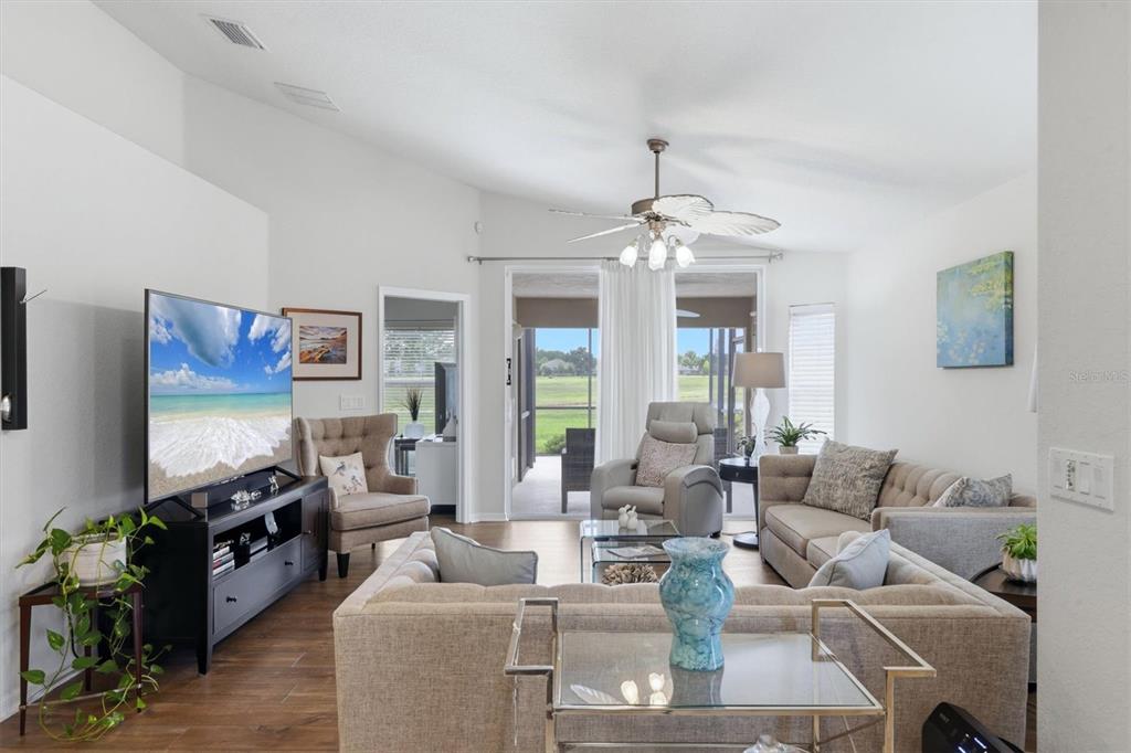A living room features a large sectional sofa, a television, and sliding doors to a patio — 3518 LAKEWOOD BOULEVARD, NORTH PORT, FL