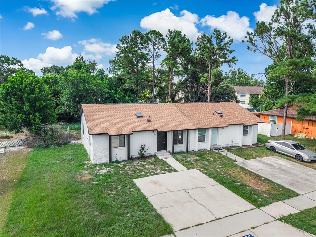 An aerial view of a single-story duplex with a brown shingled roof and concrete driveways — 12225 CORAL REEF DRIVE, ORLANDO, FL