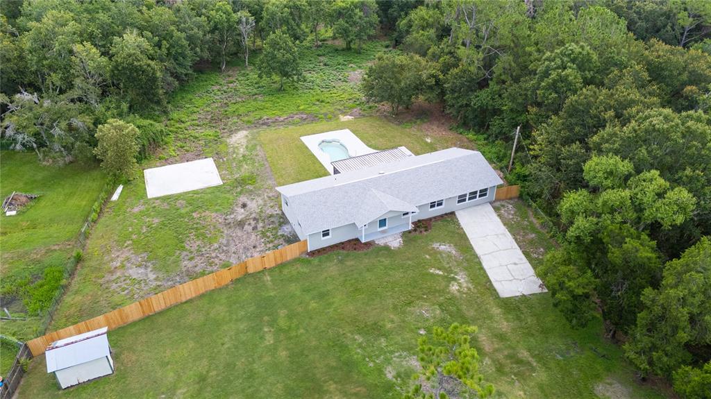 An aerial view shows a single-story house with a pool, driveway, and shed on a lot — 11033 SHERROUSE ROAD, LAKELAND, FL