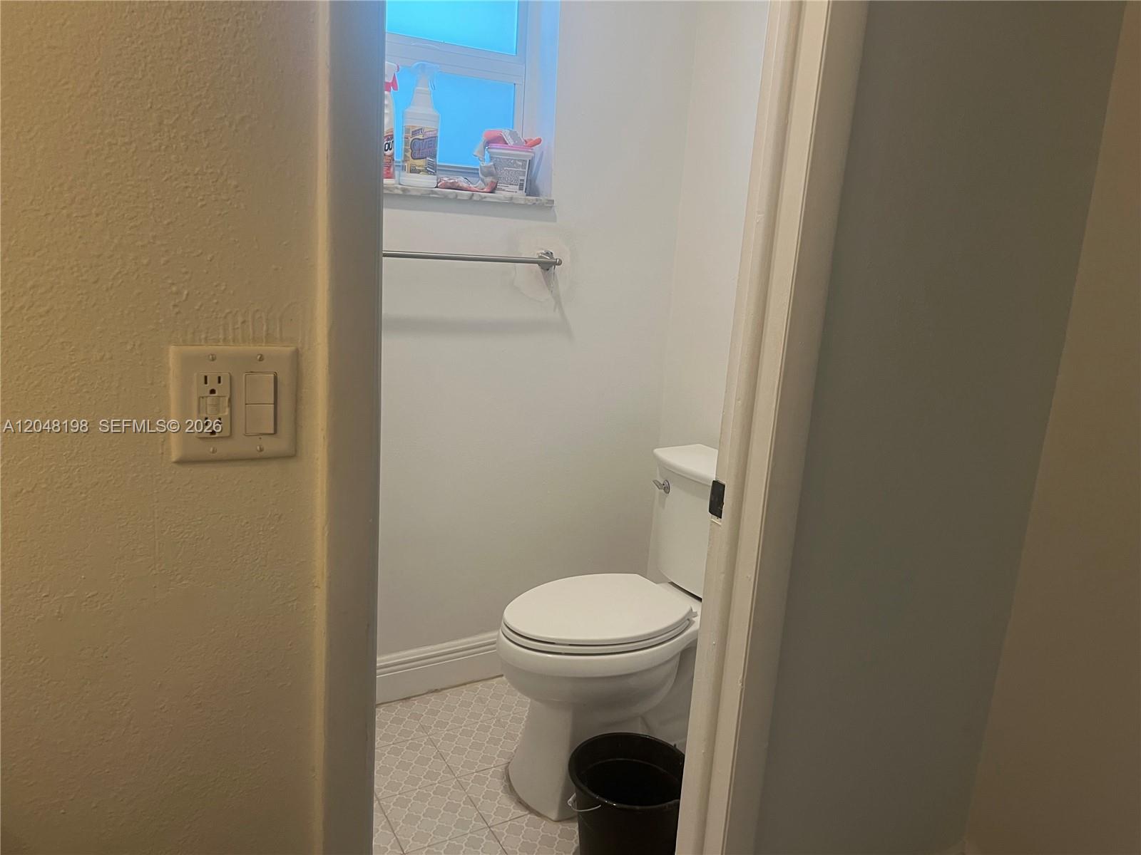 A small bathroom features a white toilet, a window, and a towel bar — 5952 NW 25th Pl # 234, Sunrise FL 33313, SUNRISE, FL