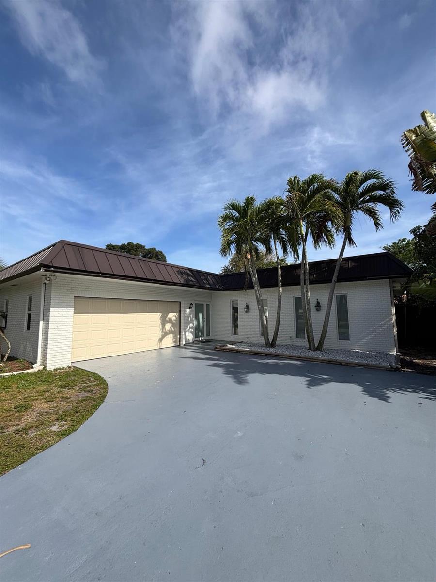A white brick house with a dark metal roof and a beige garage door — 1070 SW 18th Street, Boca Raton FL 33486, BOCA RATON, FL