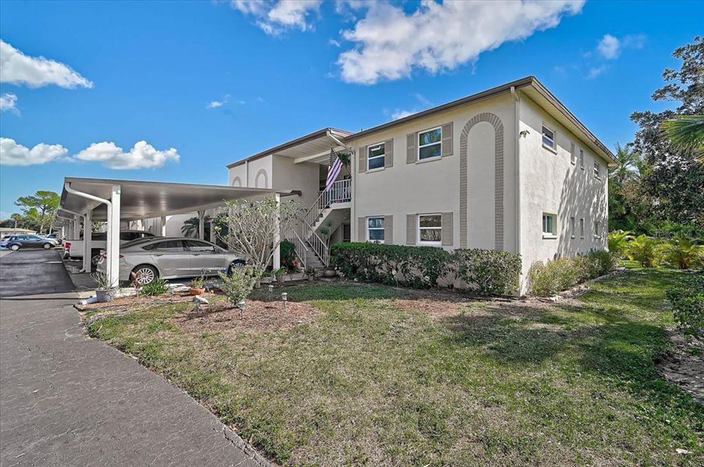 A two-story apartment building with a covered carport and an exterior staircase — 2875 SWIFTON DRIVE UNIT 58, SARASOTA, FL