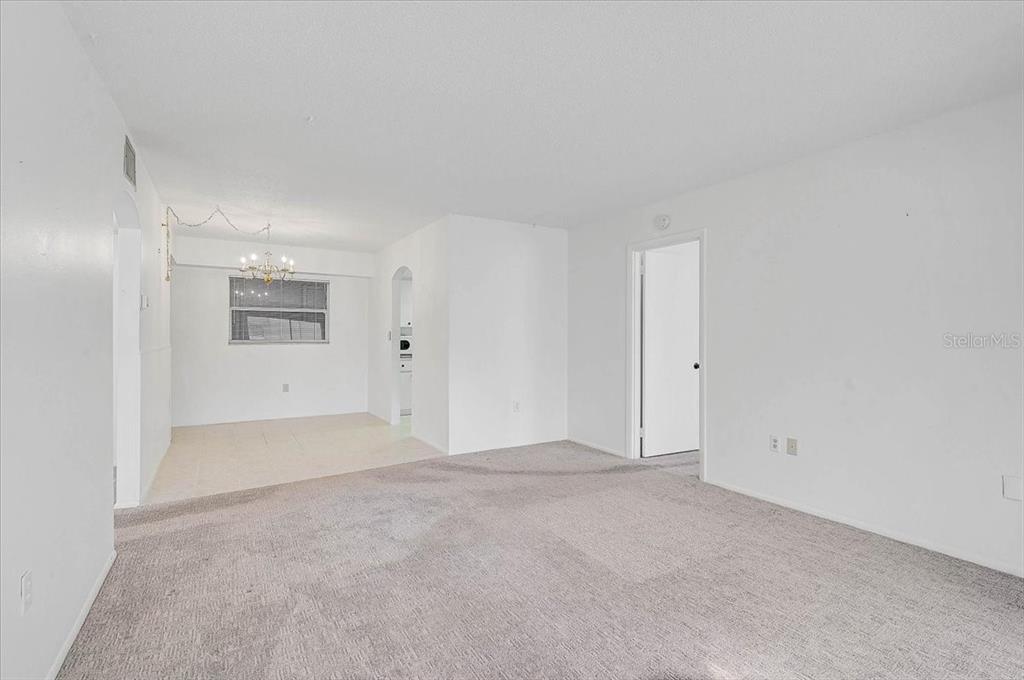 An interior view showing a carpeted living area adjacent to a tiled dining space — 2875 SWIFTON DRIVE UNIT 58, SARASOTA, FL